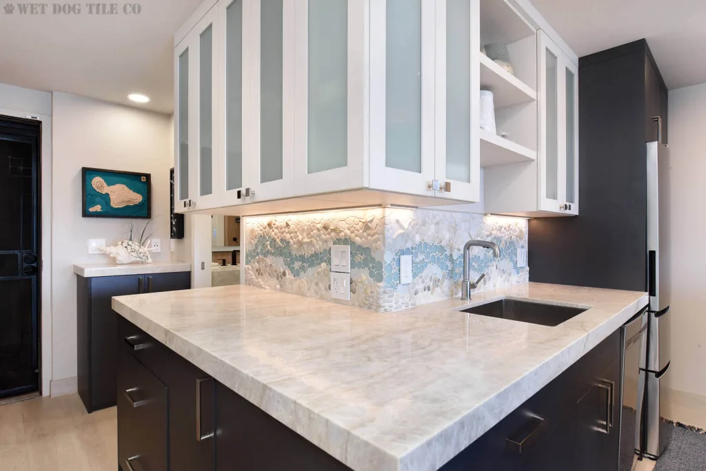 L-shaped nautical themed kitchen with a handmade mosaic starfish tile backsplash